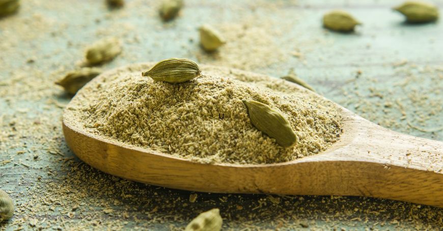 cardamomo in polvere e semi su un cucchiaio