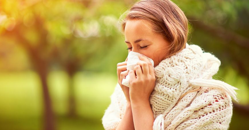 Frau putzt sich die Nase wegen Allergie, da sie keine antihistaminischen Tees genommen hat